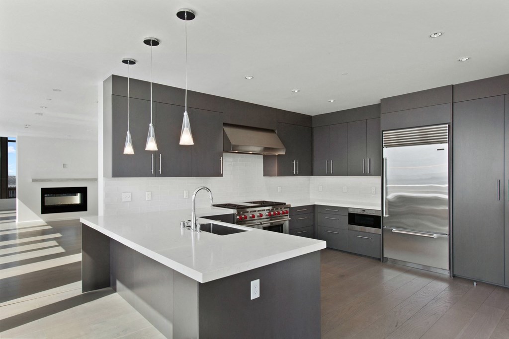 Gourmet Kitchens A modern kitchen with dark gray cabinets and white countertops at Bravern, Bellevue, Washington